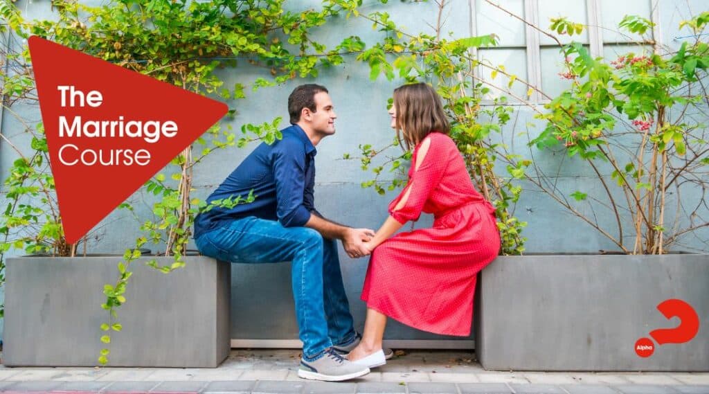 Alpha Marriage Course. An engaged couple holding hands looking at each other and the lady is wearing a bright red dress.