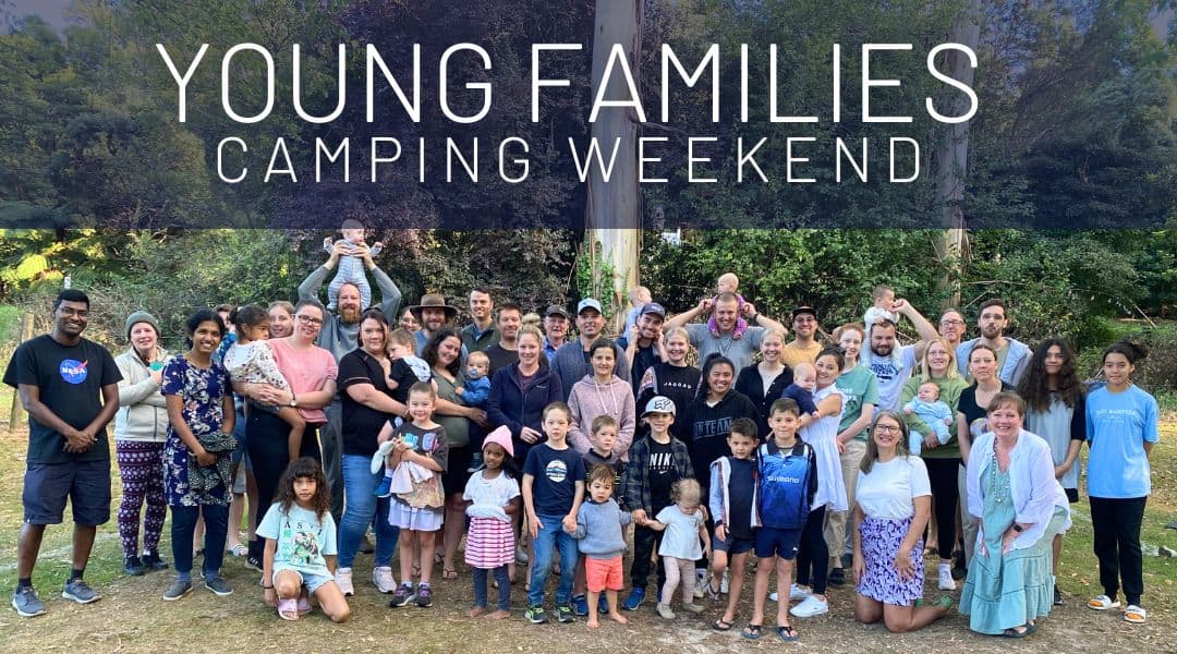 Group of young families standing at a camping ground surrounded by gum trees