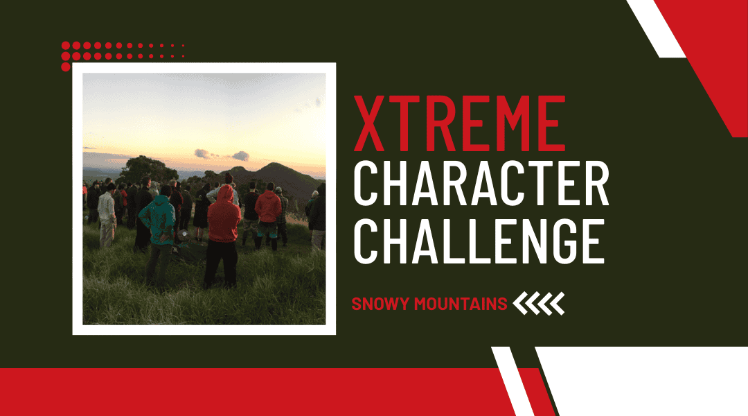 large group of men standing on a mountain top looking at the sunset with more mountains further in the distance. Title: Xtreme Character Challenge. Snowy Mountains. Title: Xtreme Character Challenge. Snowy Mountains.