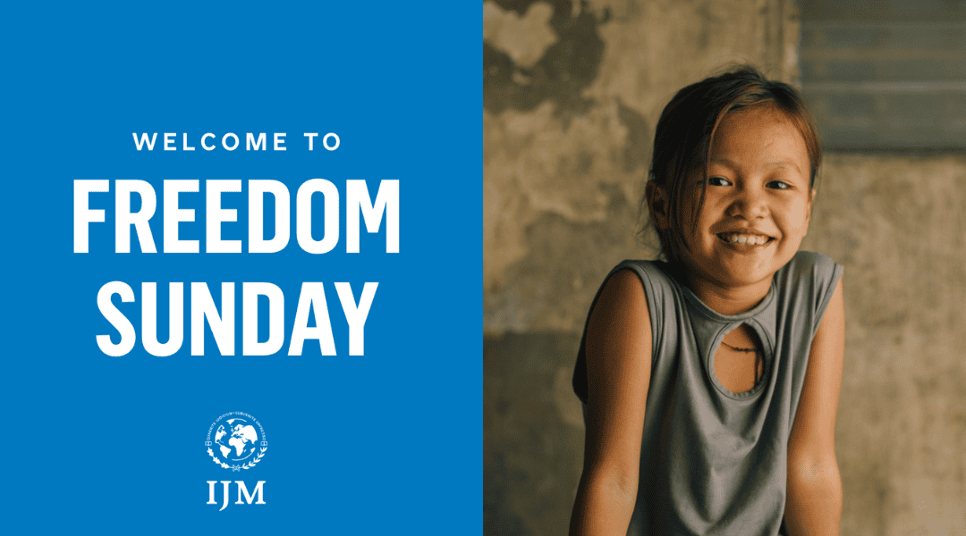 Young six year old girl smiling wearing a singlet sitting on the dirty ground. Title: Welcome to Freedom Sunday IJM.
