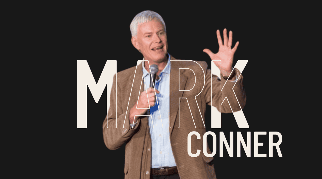 Mark Conner is a man in his sixties wearing a brown jacket with blue shirt. He has grey hair and is tall. Title: Mark Conner