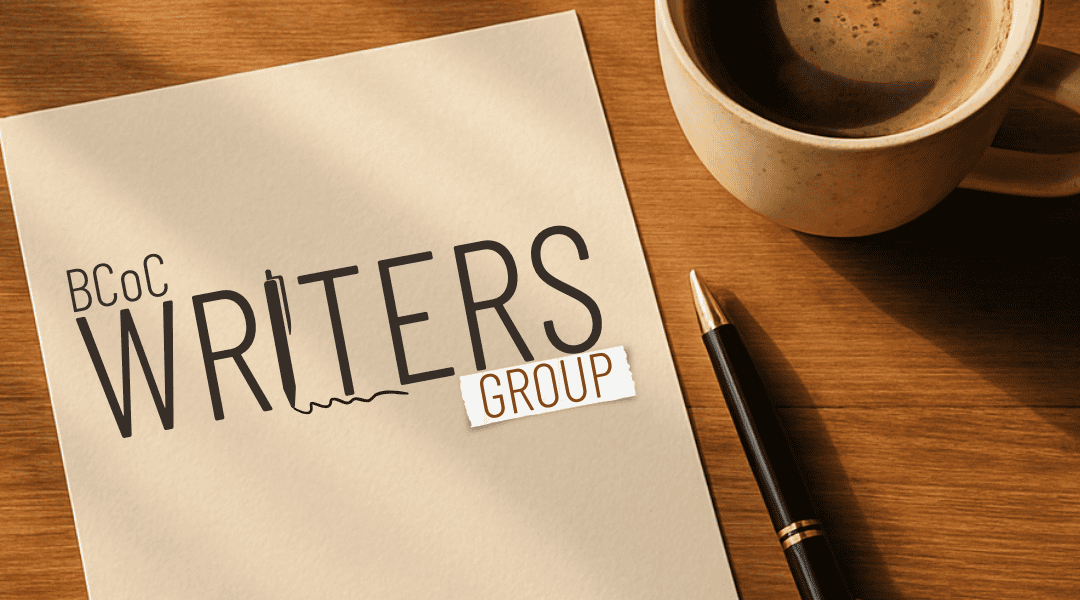 Warm timber table with notepad and cup of coffee. Pencil sits beside the notepad with the title, BCOC Writers Group.