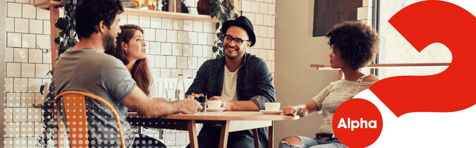 Group of four young adults sitting at a table. Two women and two men.